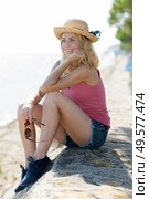 woman sitting mesmerizing on the seawall. Стоковое фото, агентство Ingram Publishing / Фотобанк Лори