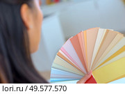 woman selecting home interior paint color from swatch catalog. Стоковое фото, агентство Ingram Publishing / Фотобанк Лори