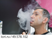 man enveloped in cloud of smoke from electronic cigarette. Стоковое фото, агентство Ingram Publishing / Фотобанк Лори