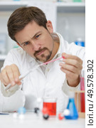 scientist holding a tube and pipette. Стоковое фото, агентство Ingram Publishing / Фотобанк Лори