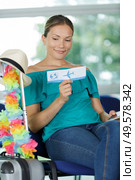 woman in the airport reading ticket. Стоковое фото, агентство Ingram Publishing / Фотобанк Лори