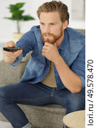 man changes the channels on the remote control. Стоковое фото, агентство Ingram Publishing / Фотобанк Лори