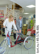 Man and woman looking at tricycle. Стоковое фото, агентство Ingram Publishing / Фотобанк Лори