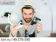 portrait of man holding globe and credit card. Стоковое фото, агентство Ingram Publishing / Фотобанк Лори