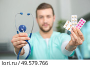young male nurse showing pills. Стоковое фото, агентство Ingram Publishing / Фотобанк Лори