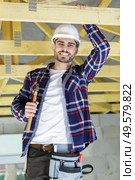 close up man hammers nail in wooden beam. Стоковое фото, агентство Ingram Publishing / Фотобанк Лори