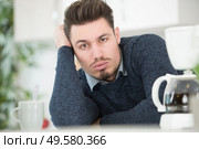 tired man coffee next to coffee machine. Стоковое фото, агентство Ingram Publishing / Фотобанк Лори