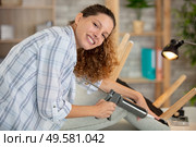 woman using sealant gun to repair a chair. Стоковое фото, агентство Ingram Publishing / Фотобанк Лори