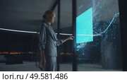 Business professional interacts with futuristic display in a modern office at night. Стоковое AI-видео, аниматор Сергей Толмачёв / Фотобанк Лори
