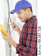 electrician at work measures the electric current. Стоковое фото, агентство Ingram Publishing / Фотобанк Лори