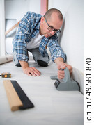 tradesman laying down linoleum flooring. Стоковое фото, агентство Ingram Publishing / Фотобанк Лори