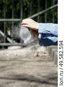 Girl’s hands blowing up a water balloon with a needle outdoors. Girl’s hands blowing up a water balloon with a needle. Стоковое фото, агентство Ingram Publishing / Фотобанк Лори