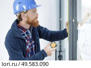 man measuring window prior to installation of roller shutter outdoors. Стоковое фото, агентство Ingram Publishing / Фотобанк Лори