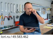 worker in an organize workshop talking on cellphone. Стоковое фото, агентство Ingram Publishing / Фотобанк Лори