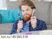man holding cigarette and electronic vaping machine. Стоковое фото, агентство Ingram Publishing / Фотобанк Лори