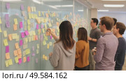 Team collaborates on project ideas using sticky notes during brainstorming session in modern office space. Стоковое AI-видео, аниматор Сергей Толмачёв / Фотобанк Лори