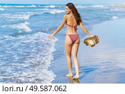 Young woman in swimwear and sunhat, enjoying the beach on her holiday.. Woman in swimwear and sunhat, enjoying the beach on her holiday. Стоковое фото, агентство Ingram Publishing / Фотобанк Лори
