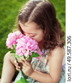 Pretty and cute child holding and sniffing flowers. Стоковое фото, агентство Ingram Publishing / Фотобанк Лори