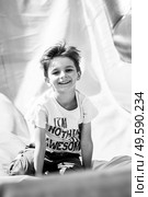 Smiling little boy playing on inflatable slide, looking at camera, black and white shot. Smiling little boy playing on inflatable slide, looking at camera. Стоковое фото, агентство Ingram Publishing / Фотобанк Лори