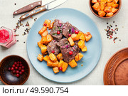 Fried pieces of beef and pumpkin.Veal meat with cranberry sauce.. Roasted beef with pumpkin. Стоковое фото, агентство Ingram Publishing / Фотобанк Лори