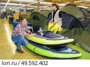 Man looking at inflatable dingys in a shop. Стоковое фото, агентство Ingram Publishing / Фотобанк Лори