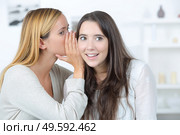 portrait of a girl telling secrets to her amazed friend. Стоковое фото, агентство Ingram Publishing / Фотобанк Лори
