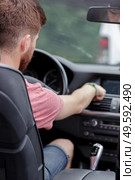 man changing radio station while driving a car. Стоковое фото, агентство Ingram Publishing / Фотобанк Лори