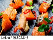 Appetizing pieces of dried salted salmon on skewers.Salty red fish. Dried fish salmon. Стоковое фото, агентство Ingram Publishing / Фотобанк Лори