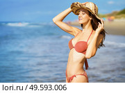Young woman in swimwear and sunhat, enjoying the beach on her holiday.. Woman in swimwear and sunhat, enjoying the beach on her holiday. Стоковое фото, агентство Ingram Publishing / Фотобанк Лори