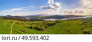 Spring mountain panorama. Lake Czorsztyn on Dunajec river. Village in green forest and meadow hills. Cloudy evening sunset sky. Aerial view of Tatra range woodland landscape. Poland, Malopolska region. Стоковое фото, агентство Ingram Publishing / Фотобанк Лори