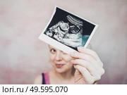 Woman holding the ultrasound of her baby. Стоковое фото, агентство Ingram Publishing / Фотобанк Лори