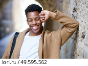 Happy black man laughing outdoors. Cuban student in urban background.. Happy young black man laughing in urban background. Стоковое фото, агентство Ingram Publishing / Фотобанк Лори