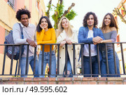 Multi-ethnic group of friends gathered in the street leaning on a railing. Young people having fun together.. Multi-ethnic group of friends gathered in the street leaning on a railing. Стоковое фото, агентство Ingram Publishing / Фотобанк Лори