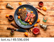 Sliced beef steak roasted with kumquat,rosemary and spices.Veal entrecote on a plate. Juicy beef steak with kumquat,top view. Стоковое фото, агентство Ingram Publishing / Фотобанк Лори