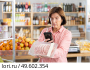 Female purchaser scanning QR code or barcode of pork fillet in shop. Стоковое фото, фотограф Яков Филимонов / Фотобанк Лори