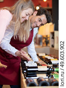 male sommelier helping woman to buy bottle of wine. Стоковое фото, агентство Ingram Publishing / Фотобанк Лори