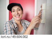 female technician sets the thermostat. Стоковое фото, агентство Ingram Publishing / Фотобанк Лори