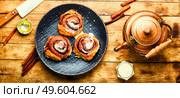 Cinnabones with cinnamon and mascarpone cheese.Homemade buns on a plate.Cinnamon rolls or cinnabon. Delicious baked cinnabon buns with cream sauce. Стоковое фото, агентство Ingram Publishing / Фотобанк Лори