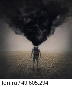 Surreal scene of a lone man in the field with dense black smoke instead his head. Fatigue and annoyed person suffering emotional crisis. Mental burnout and explosion. Depression and despair concept. Стоковое фото, агентство Ingram Publishing / Фотобанк Лори
