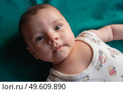 Макросъёмка: крошечная ручка младенца крепко сжимает взрослый палец на размытом фоне жёлтого и синего. Мягкий естественный свет подчёркивает бархатистую кожу и трогательность момента. Образ символизирует доверие, связь поколений и заботу. Стоковое фото, фотограф Владислав Войтов / Фотобанк Лори