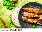 Appetizing pieces of dried salted salmon on skewers.Salty red fish. Dried fish salmon. Стоковое фото, агентство Ingram Publishing / Фотобанк Лори