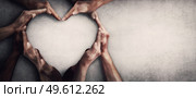 Different people unite for a common purpose as diverse person hands join together and create heart shape, isolated on grey wall background with copy space. Race diversity and love an teamwork concept. Стоковое фото, агентство Ingram Publishing / Фотобанк Лори