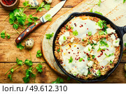 Israeli shakshuka made from fried eggs, tomato, minced lamb and hot spices.. Israeli shakshuka,scrambled eggs. Стоковое фото, агентство Ingram Publishing / Фотобанк Лори