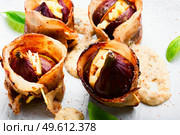 Figs stuffed with suluguni cheese baked with bacon and Greek yogurt sauce.Baked figs.Close up. Figs roasted in bacon with cheese,macro. Стоковое фото, агентство Ingram Publishing / Фотобанк Лори