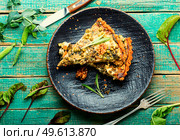Rural pie with swiss chard, feta cheese and green peas. Pie with herbs on rustic wooden background. Open pie with herbs and green peas. Стоковое фото, агентство Ingram Publishing / Фотобанк Лори