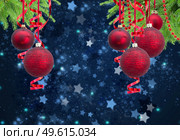 Red christmas balls garlands and evergreen fir tree on blue winter background. Red christmas balls. Стоковое фото, агентство Ingram Publishing / Фотобанк Лори