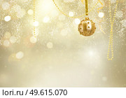 Golden christmas balls garland on glowing and shiny golden background with copy space. Golden christmas balls. Стоковое фото, агентство Ingram Publishing / Фотобанк Лори