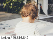 Backview of a baby playing in nature. Стоковое фото, агентство Ingram Publishing / Фотобанк Лори