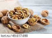 Purified walnuts in a white bowl on a wooden background. . Стоковое фото, агентство Ingram Publishing / Фотобанк Лори