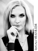 blonde girl in a black trouser suit with blue eyes on the background of a granite quarry from gray rubble. Стоковое фото, агентство Ingram Publishing / Фотобанк Лори